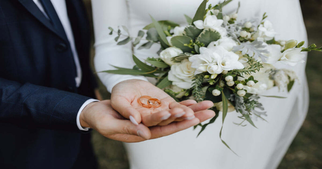 Wedding rings beside a calendar on a warm background for a guide to choosing the best month for a wedding.