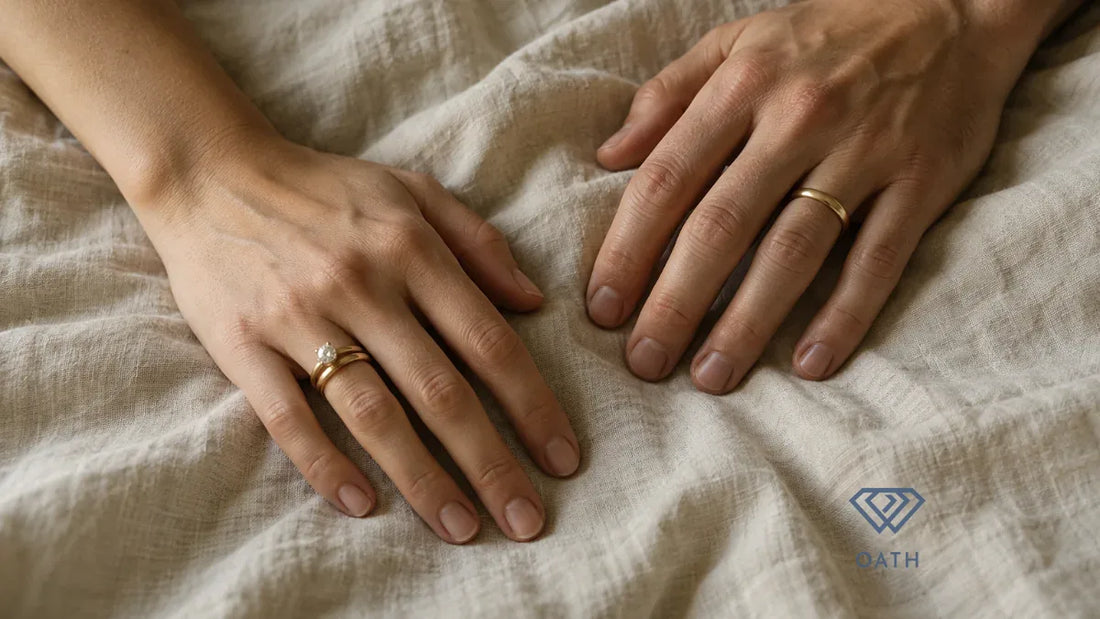 Left hand wearing a diamond engagement ring and gold wedding band beside a right hand wearing a plain gold wedding band