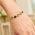 14K yellow gold bracelet with round multicolored gemstones on a fine chain