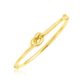 14K yellow gold bangle bracelet with polished knot detail