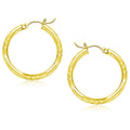 14K yellow gold hoop earrings with diamond-cut faceted finish, 25mm