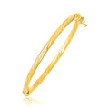 14K yellow gold children's bangle with spiral motif texture