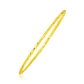 14K yellow gold thin twisted slip-on bangle with shiny finish