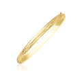 10K yellow gold Florentine bangle with carved botanical pattern